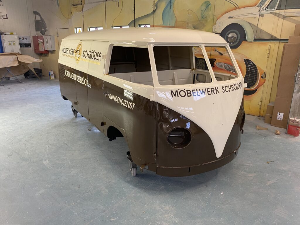 Zweifarbig lackierter Oldtimer-Transporter in einer Werkstatt, mit der Aufschrift Möbelwerk Schröder