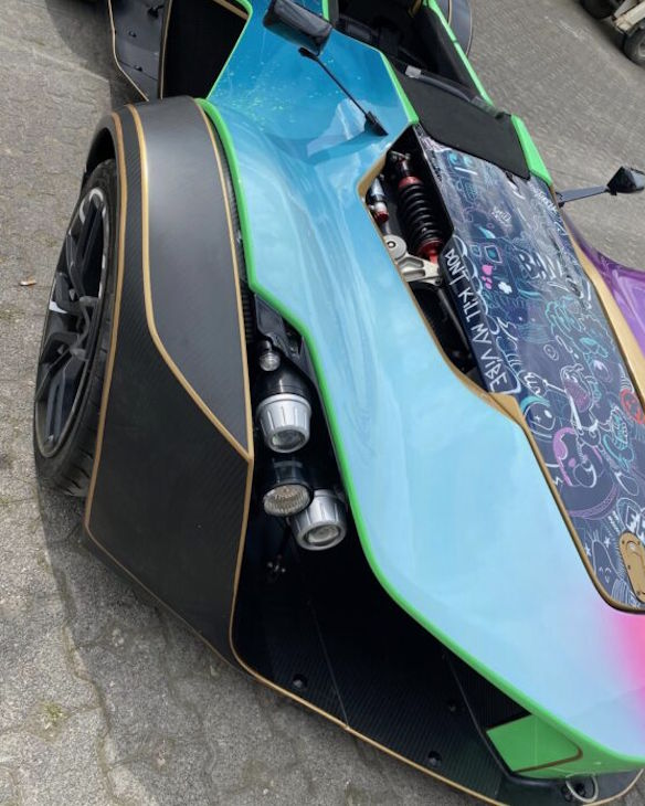 Nahaufnahme eines bunten, futuristischen Sportwagens mit Carbon-Details und auffälliger Lackierung